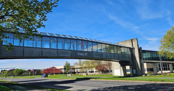 Image of glass walkway above the road with iPark logo