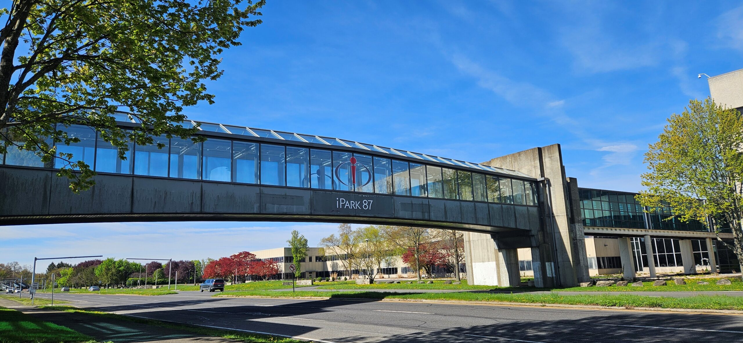 Image of glass walkway above the road with iPark logo